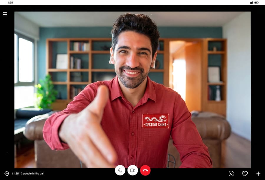 hombre con barba y camisa roja extendiendo la mano a forma de saludos